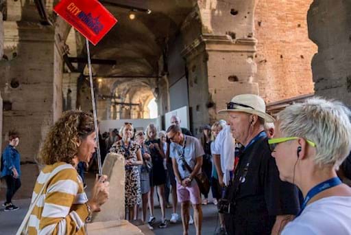 Tourists in Rome listening to their tour guide inside the Colosseum