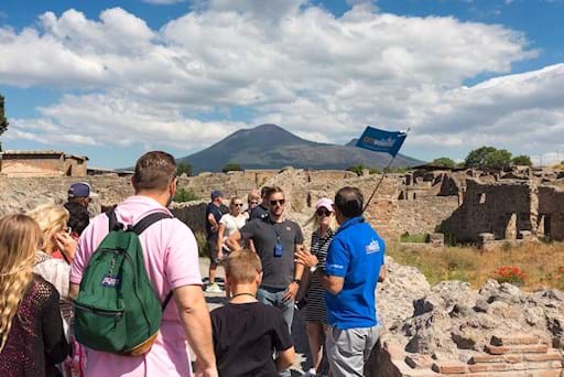 Pompeii Group tour listening to their guide with Mt. Vesuvius at the back