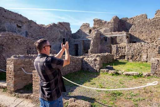 tourists admiring the ruins of Pompeii