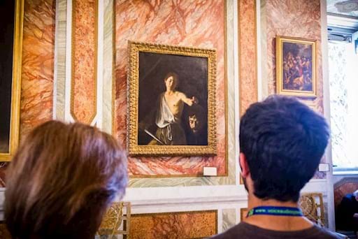 Couple looking at one of Caravaggio painting inside the Borghese Gallery